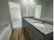 Primary bathroom featuring a dual sink vanity with gray cabinets, granite countertop, and a soaking tub at 299 Phil Jack Rd, Dunn, NC 28334
