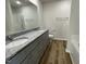 Bathroom featuring a dual sink vanity with gray cabinets, granite countertop, and a glass-enclosed shower at 299 Phil Jack Rd, Dunn, NC 28334