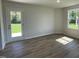 Living room showcasing natural light, wood-look flooring, neutral paint and access to the backyard through a glass door at 299 Phil Jack Rd, Dunn, NC 28334