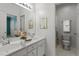 Bright bathroom featuring double sinks, white cabinets, and decorative floral arrangements at 30038 Village Park Dr, Chapel Hill, NC 27517