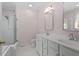 Bathroom featuring double sinks, white cabinets, and a tub with glass doors, offering a spa-like feel at 30038 Village Park Dr, Chapel Hill, NC 27517