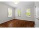 Bright bedroom with hardwood floors, white walls, and large windows with natural light at 30038 Village Park Dr, Chapel Hill, NC 27517
