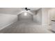 Large bonus room with neutral carpet, ample natural light, and a ceiling fan at 30038 Village Park Dr, Chapel Hill, NC 27517
