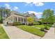 Inviting home with a covered porch, lush lawn, and a driveway leading to a detached garage at 30038 Village Park Dr, Chapel Hill, NC 27517