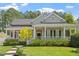 Charming home with a welcoming front porch, lush landscaping, and manicured lawn at 30038 Village Park Dr, Chapel Hill, NC 27517