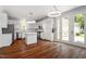 Well-lit kitchen featuring an island, stainless steel appliances, hardwood floors, and adjacent glass doors at 30038 Village Park Dr, Chapel Hill, NC 27517