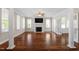 Bright living room with hardwood floors, large windows, and a fireplace, creating an inviting ambiance at 30038 Village Park Dr, Chapel Hill, NC 27517