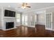 Open living room with hardwood floors, fireplace and French doors leading into another living space at 30038 Village Park Dr, Chapel Hill, NC 27517