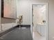 Neutral wet bar featuring modern sink fixture and view into an adjacent white bathroom at 30038 Village Park Dr, Chapel Hill, NC 27517