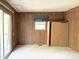 Bedroom with wood-paneled walls, window, sliding door, and carpeted floors at 311 N Nash St, Hillsborough, NC 27278