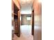 Hallway with wood-paneled walls leading to a room with a window and closet at 311 N Nash St, Hillsborough, NC 27278