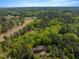 Aerial view of the estate surrounded by lush, mature trees and a nearby golf course at 3203 Cameron Dr, Henderson, NC 27536