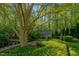 Secluded backyard featuring a pool, lush landscaping, and a charming garden shed at 3203 Cameron Dr, Henderson, NC 27536