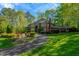 Beautiful brick home with a circular driveway, lush green lawn and manicured landscaping at 3203 Cameron Dr, Henderson, NC 27536