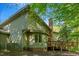 Charming home featuring a wooden deck, brick accents, and surrounded by lush greenery at 3203 Cameron Dr, Henderson, NC 27536