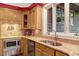The kitchen offers wood cabinets, a stainless steel microwave, and a sink beneath a window with natural light at 3203 Cameron Dr, Henderson, NC 27536