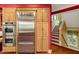 The kitchen showcases stainless steel appliances built into wooden cabinets adjacent to the staircase and outdoor view at 3203 Cameron Dr, Henderson, NC 27536