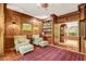 Comfortable library with wood paneling, built-in bookshelves, and plush armchairs for a cozy reading space at 3203 Cameron Dr, Henderson, NC 27536