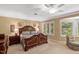 The main bedroom features a king bed, nightstands, a sitting area and bright windows at 3203 Cameron Dr, Henderson, NC 27536