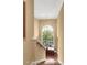A staircase ascends toward a window, providing natural light with greenery views, brightening the neutral hallway at 3203 Cameron Dr, Henderson, NC 27536