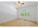 This bedroom features a ceiling fan, wood floors, and a large window at 3605 Moonlight Dr, Chapel Hill, NC 27516