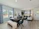 Open-concept dining and living area with a stylish table, bench seating, and expansive windows at 3701 Rosebush Dr, Zebulon, NC 27597