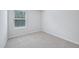 A bright bedroom with neutral carpeting, light gray walls, and a window offering natural light at 3705 Rosebush Dr, Zebulon, NC 27597