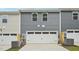 Townhome rear exterior with light gray siding, white garage door, and gray AC unit at 3705 Rosebush Dr, Zebulon, NC 27597