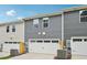 Rear exterior view of townhomes with garages and light-colored siding at 3705 Rosebush Dr, Zebulon, NC 27597
