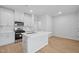 Modern kitchen with stainless steel appliances, white cabinets, and an island with a sink at 3705 Rosebush Dr, Zebulon, NC 27597