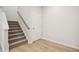 Staircase featuring neutral paint and wood railing and carpeted stairs at 3705 Rosebush Dr, Zebulon, NC 27597