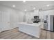 Modern kitchen with a central island, stainless steel appliances, and new hardwood floors for a contemporary look at 3707 Rosebush Dr, Zebulon, NC 27597