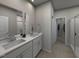 Modern bathroom features dual sinks, sleek countertops, and a glass-enclosed shower at 3709 Rosebush Dr, Zebulon, NC 27597