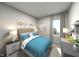 Tranquil bedroom with blue accents, cozy bedding, and ample natural light from the window at 3709 Rosebush Dr, Zebulon, NC 27597