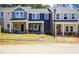 Charming, newly constructed townhomes with colorful facades and inviting front lawns at 3709 Rosebush Dr, Zebulon, NC 27597