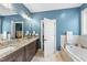 Spacious bathroom with a granite-topped vanity, soaking tub, and linen closet at 3805 Watermark Dr, Franklinton, NC 27525