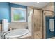 Bright bathroom with a soaking tub, glass enclosed shower, and window at 3805 Watermark Dr, Franklinton, NC 27525