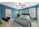 Comfortable bedroom with blue walls, a ceiling fan, and closet leading to bathroom at 3805 Watermark Dr, Franklinton, NC 27525