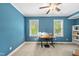 Bright bedroom with two windows, blue walls, and a modern desk and chair at 3805 Watermark Dr, Franklinton, NC 27525