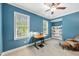 Bright bedroom with two windows, blue walls, and comfortable seating with built-in shelves at 3805 Watermark Dr, Franklinton, NC 27525