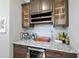 Stylish wet bar area featuring granite countertops, wine storage, and glass-front cabinets at 3805 Watermark Dr, Franklinton, NC 27525