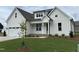 Charming two-story white home featuring a covered porch, attached garage, and manicured lawn at 3820 Fairway View Dr # 16, Fuquay Varina, NC 27526