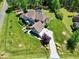 Aerial view of home with an expansive driveway, a backyard patio, and an outdoor kitchen and firepit at 4001 Belmont Forest Way, Raleigh, NC 27606