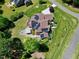 An aerial view showcases a beautiful home with solar panels, deck, patio, outdoor seating, and green yard at 4001 Belmont Forest Way, Raleigh, NC 27606