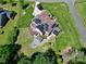 An aerial view of a home with solar panels, deck, patio with seating, and lush, manicured landscaping at 4001 Belmont Forest Way, Raleigh, NC 27606