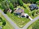 Aerial view of large single Gathering home featuring a lush lawn, circular driveway, and mature landscaping at 4001 Belmont Forest Way, Raleigh, NC 27606