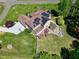Aerial view of a home featuring solar panels, a backyard deck, patio, outdoor kitchen and firepit area at 4001 Belmont Forest Way, Raleigh, NC 27606