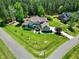Expansive aerial view of a brick home with a large yard, mature trees, and basketball court at 4001 Belmont Forest Way, Raleigh, NC 27606
