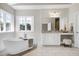 Luxurious bathroom featuring a freestanding tub, elegant vanity, and ample natural light at 4001 Belmont Forest Way, Raleigh, NC 27606