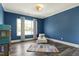 Charming blue bedroom offers a cozy retreat with wood floors and natural light at 4001 Belmont Forest Way, Raleigh, NC 27606